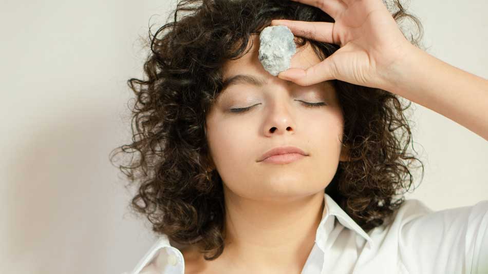 Woman meditating with crystal